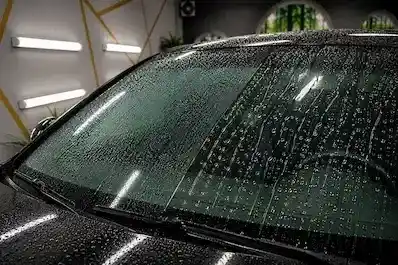 Vízcseppek gyöngyöznek a vízlepergető bevonattal kezelt szélvédőn
